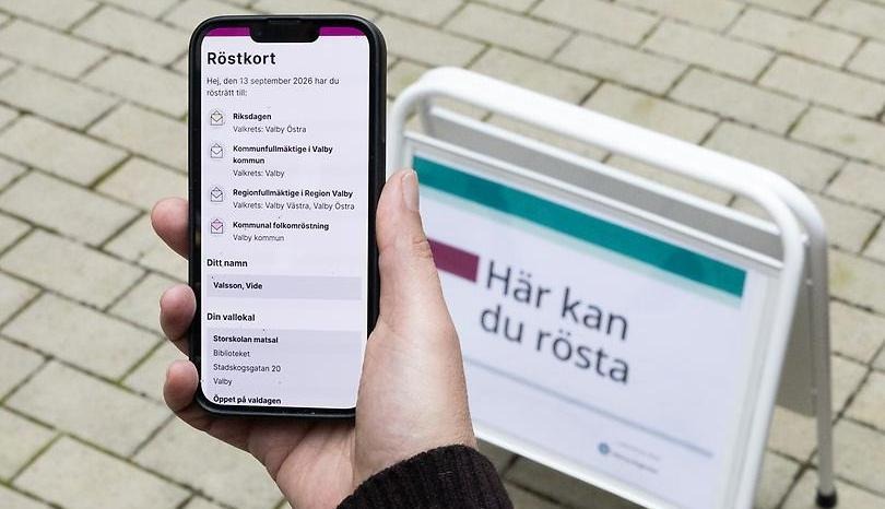 Telefon i hand+skylt: Här kan du rösta.