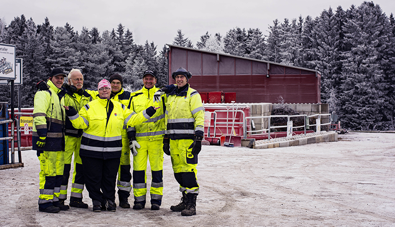 Medarbetare på återvinningscentral står tillsammans på lastkaj.