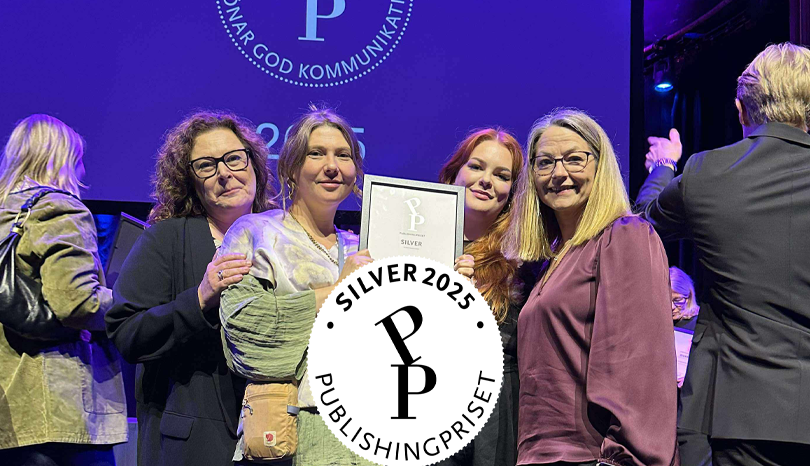 Fyra glada kvinnor med ett diplom på en gala.