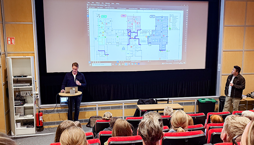 Två personer visar bilder och berättar om hur lokaler ska byggas om.