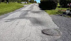 Närbild på spricka i asfaltsväg. 